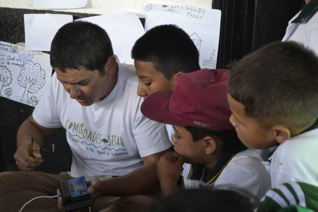 Juan Pablo Soler, co-fundador de Comunidades Seeta e investigador en la organización no gubernamental Censat Agua Viva, le enseña a los niños de la escuela de Nueva Llanada sobre energía solar.