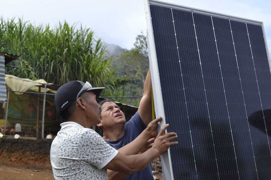 Juan Pablo Soler y Bernardo Torres trabajan en el panel solar que le provee energía al hogar que Torres comparte con Acened Higuita, su esposa.