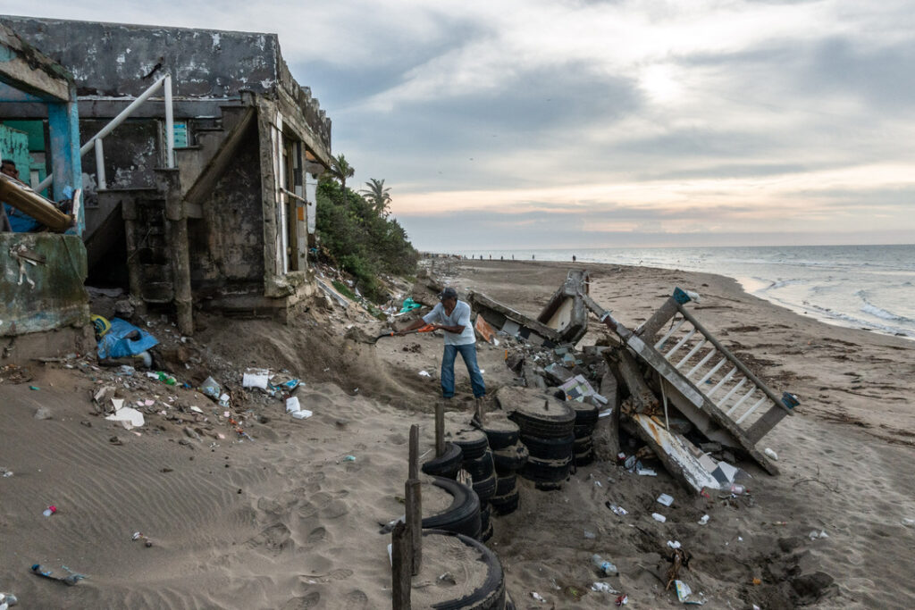 Todas las tardes, este señor -quien vive en la comunidad de Sanchez Magallanes (Tabasco, México)- echa arena en los cimientos de su casa. Hace cinco años, el mar y la erosión destruyeron gran parte de su vivienda. Unos siete días después de haberse tomado esta foto, otra parte de la casa se derrumbó. Crédito: César Rodríguez / Cruz Roja Internacional