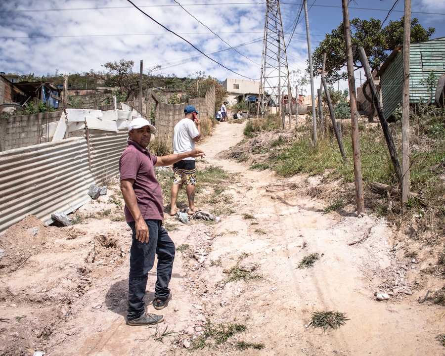 Adalberto Gleidson Vieira (no celular) e Johil Cristóvão de Sena Silva caminham por uma das ruas onde será implementado poste fotovoltaico. Foto: Amanda Magnani