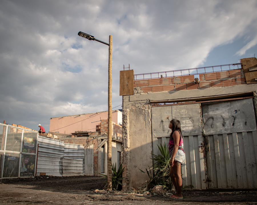 Naiara Rocha, na frente de sua casa na comunidade GK, onde foi implementado um dos postes fotovoltaicos. Foto: Amanda Magnani