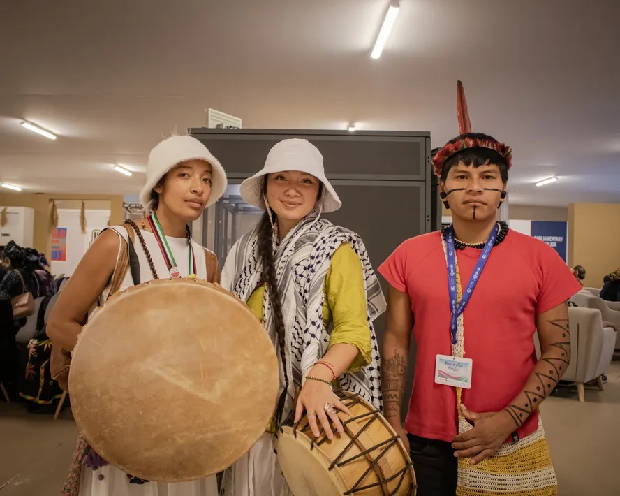 Mesiah (esquerda) com companheiros do seu povo, em frente ao pavilhão indígena Foto: Amanda Magnani
