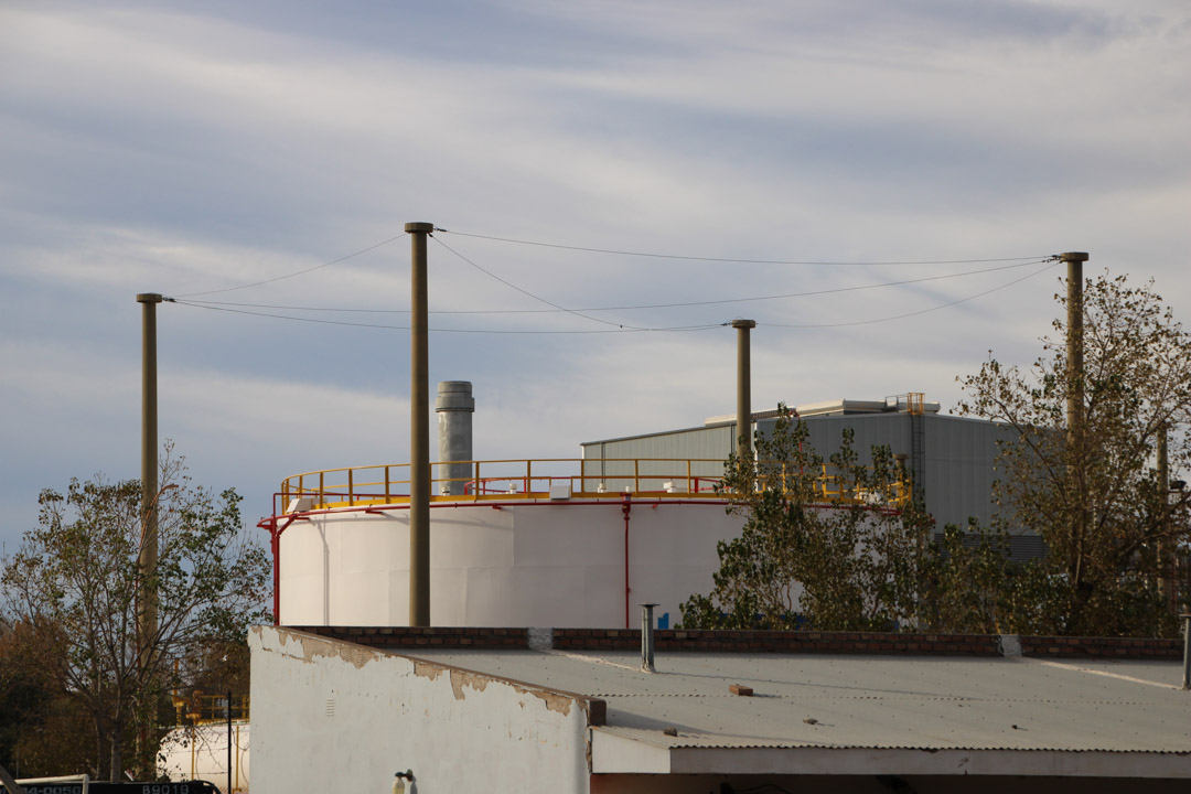 YPF Refinería Plaza Huincul, 12 de mayo de 2023
La foto digital de la chimenea detrás de un tanque dentro de la Refinería Plaza Huincul YPF no demuestra señales visibles de emisiones de gases o bruma de calor, en cuanto la captura de pantalla del video de OGI filmado al mismo tiempo registra lo que aparentan ser plumas de contaminación de hidrocarburos que incluyen metano y otros compuestos nocivos que resultan del proceso de combustión incompleta. Foto: Earthworks